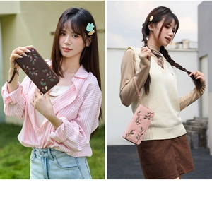 Detail of embroidered floral long wallets in dark coffee and light pink colors