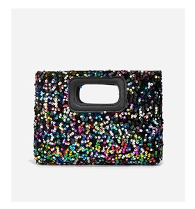 Close-up of vibrant rainbow sequins on a rectangular handbag with a black leather handle