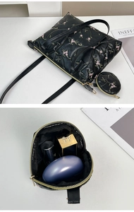 Detail view of black PU tote with floral embroidery and matching round coin purse