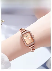 Dettaglio dell'orologio rettangolare di lusso in oro rosa con strass sul polso femminile