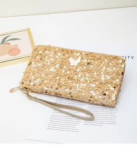Detailed view of golden sequin long wallet with wrist strap and white butterfly accent