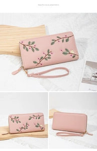 Detailed close-up of pink litchi grain leather long wallet with floral embroidery
