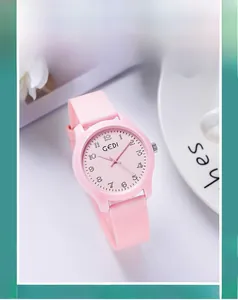Close-up of pink quartz watch with silicone strap and 1-12 Arabic numerals on simple dial