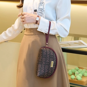 Mini sac croissant élégant avec motif monogramme et fermeture éclair dorée en scène
