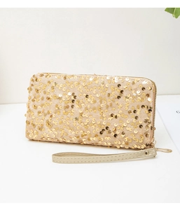 Detail of long evening clutch bag featuring golden sequins and champagne wrist strap