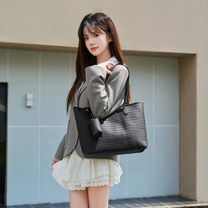 Large black woven texture tote bag with a matching small pouch for urban commuting