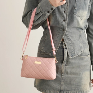 Pink quilted square crossbody bag with gold metal plate and adjustable fabric strap