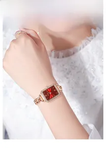 Dettaglio dell'orologio quadrato oro rosa con quadrante rosso e lunetta con cristalli