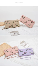 Detail of embroidered floral patterns on long wallets with matching leather wrist straps