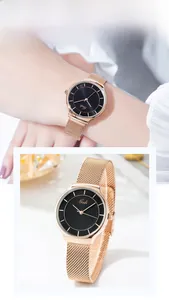 Détail de la montre en maille or rose avec cadran noir portée par une femme