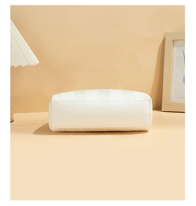 Detailed view of white quilted PU leather handbag with V-shaped stitching and smooth texture