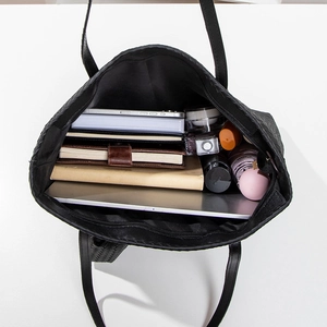 Large black woven leather tote bag for women showing spacious interior for essentials