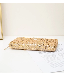 Detailed side view of a gold sequin evening clutch bag with metallic zipper and elegant textures