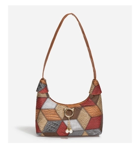 Detail of color-block underarm bag featuring pearl charms and mixed leather textures