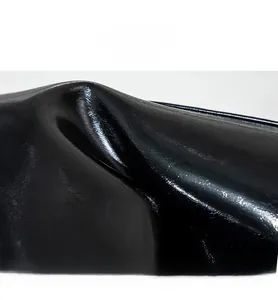 Gros plan sur le similicuir noir brillant montrant la texture douce du sac baguette