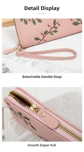 Close-up of pink flower embroidery and smooth metal zipper on the pebbled leather wallet