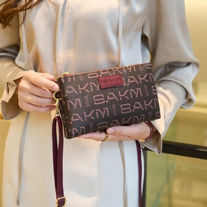 Brown monogram ladies bag with dual zippers, SAKM pattern, and crossbody leather strap