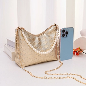 Goldene gesteppte Schultertasche mit Perlenobergriff und Metallkette auf weißem Grund