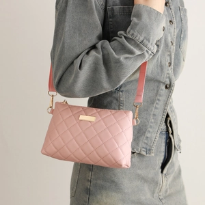 Pink quilted crossbody bag with gold hardware shown on a model wearing denim outfit
