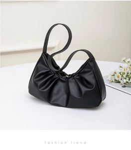 Detailed side view of the black pleated leather cloud bag with delicate PU texture