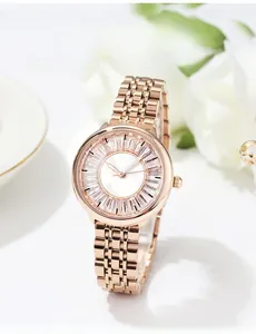 Détail d'une montre chic en or rose avec lunette sertie de cristaux et cadran blanc élégant