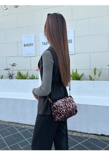 Detail view of purple gradient sequin crossbody bag with a slim black shoulder strap