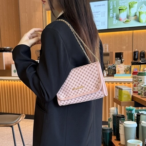 Chic pink monogram chain crossbody bag for women shown in a modern cafe setting