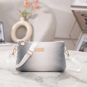 Detail of chevron quilted crossbody bag with gradient grey finish and gold hardware
