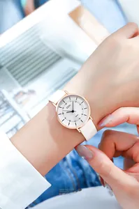 Close-up of stylish women quartz watch with white leather strap and rose gold case