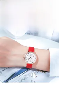 Detailed view of women's quartz watch with rose gold case and red leather strap