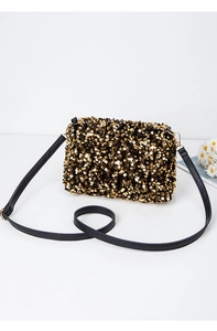 Detailed close-up of golden and black sequins texture on a luxury shoulder bag with gold hardware