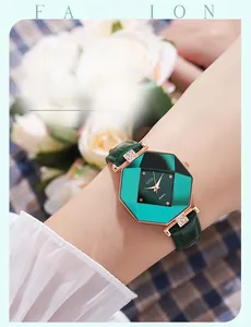 Close-up of octagonal emerald green dial watch with gold case and green leather strap