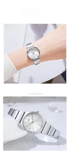 Close-up of women's silver quartz watch with metal link strap and sunray dial detail