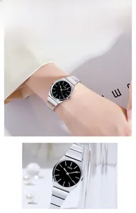 Macro view of silver bamboo-style stainless steel watch strap and sleek black watch dial