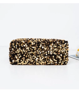 Close-up of golden sequins on a luxury evening clutch bag with black fabric base