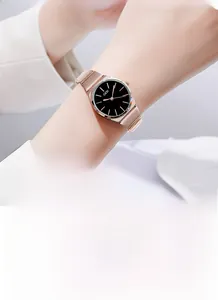 Detail of elegant rose gold bamboo style watch with minimalist black dial and strap
