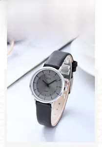 Detail of GEDI quartz watch with sunburst grey dial and black leather strap on desk