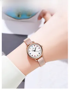 Close-up of rose gold quartz watch with a colorful zircon birthstone dial on wrist