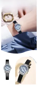 Detail of blue mother-of-pearl watch face with Roman numerals and black leather strap
