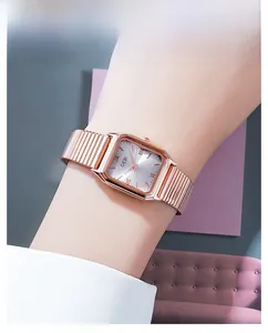 Close-up of a rose gold square quartz watch with Roman numerals on a woman's wrist