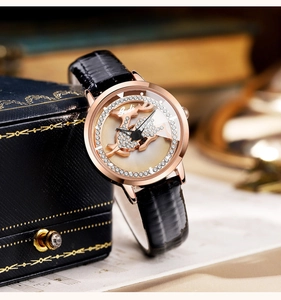 Close-up of rose gold watch with rhinestone reindeer dial and black leather strap