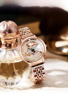 Macro detail of rose gold quartz watch with diamond deer dial and solid steel link bracelet