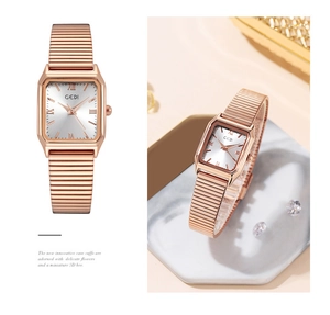 Detail of rose gold rectangular watch with Roman numerals and elastic metal band