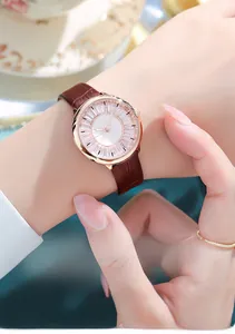 Close-up of elegant rose gold watch with sparkling rhinestones and brown leather strap