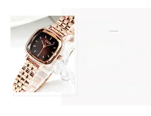 Close-up of rose gold square watch with a gradient brown dial and metallic link strap