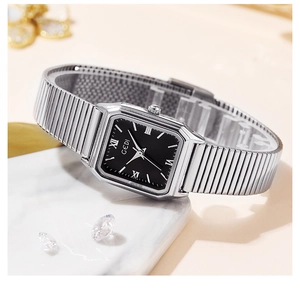 GEDI square quartz watch with black dial and silver mesh strap on marble stand