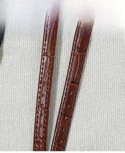 Detail of brown leather watch strap featuring bamboo pattern and tonal stitching