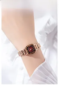Chic square rose gold watch with a deep red gradient sunray dial on a woman's wrist