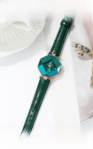 Macro view of emerald green octagonal watch face with rose gold case and crystal accents
