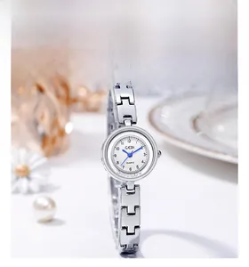 Detailed macro of a silver-tone chain watch with white dial and blue hands